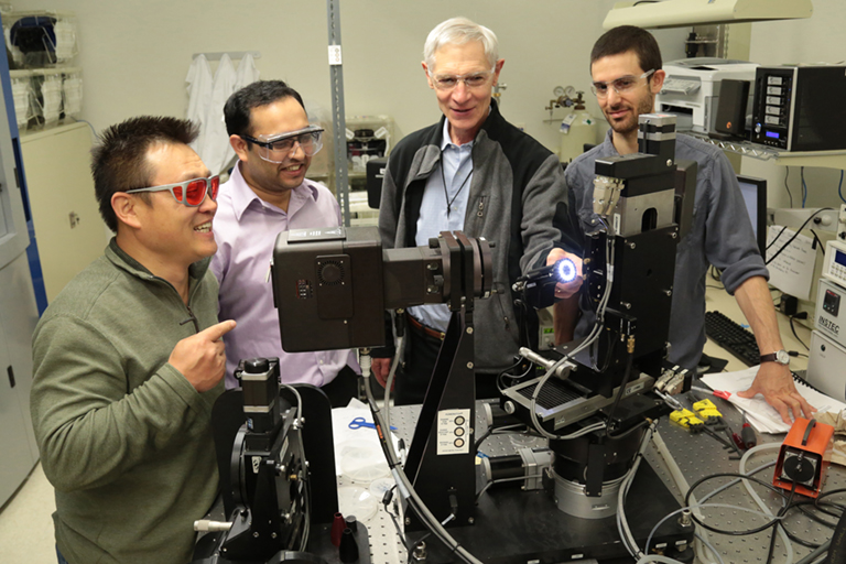 Professor Alain Diebold works in his lab with some graduate students