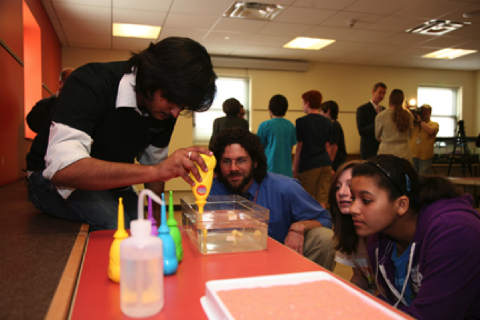Graduate Student does science experiments with area high school students