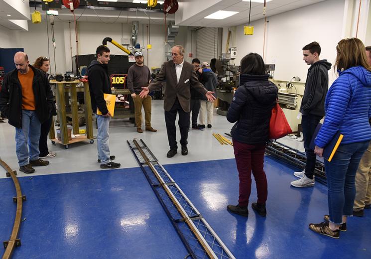 Douglas Holzhauer shows guests parts of a bridge the Civil Engineering students are building.